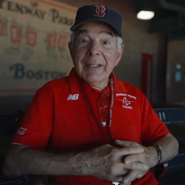 elderly man in red shirt and baseball cap